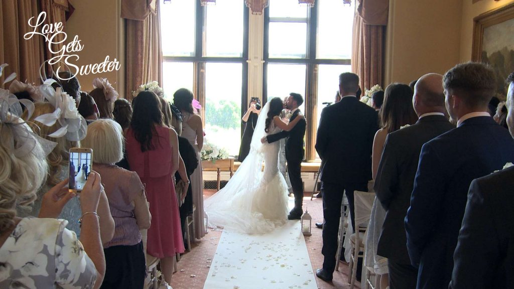 Their Cumbria wedding videographer films the moment the bride and groom enjoy a kiss after being announced as husband and wife at armathwaite hall in the lake district