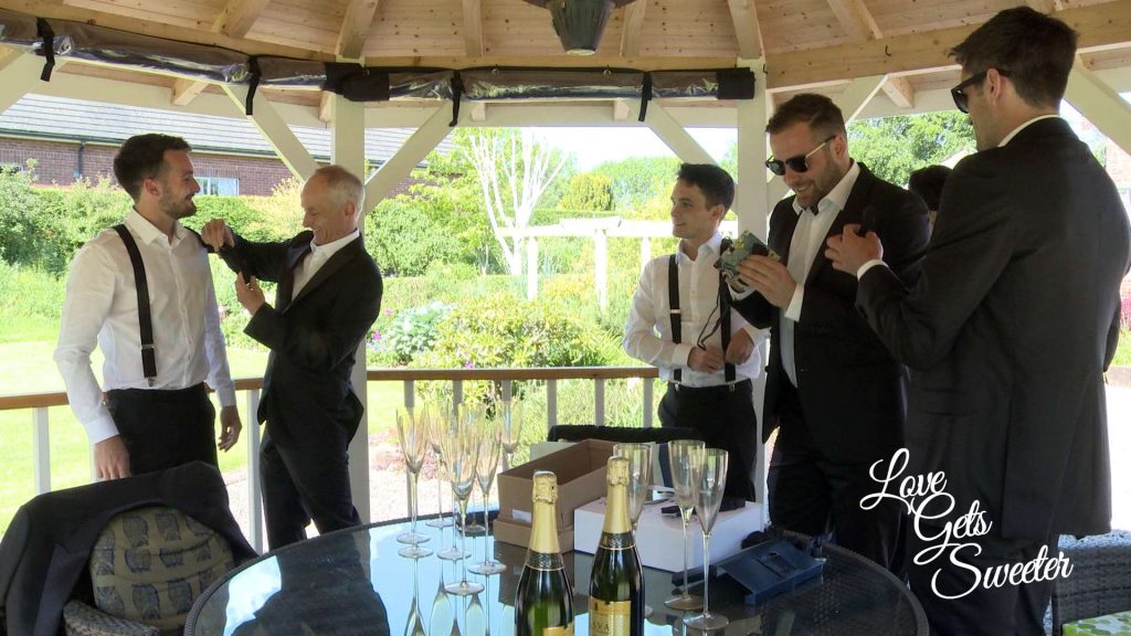 groom and ushers getting ready in the parents garden under the gazebo on a hot summers day in Penrith